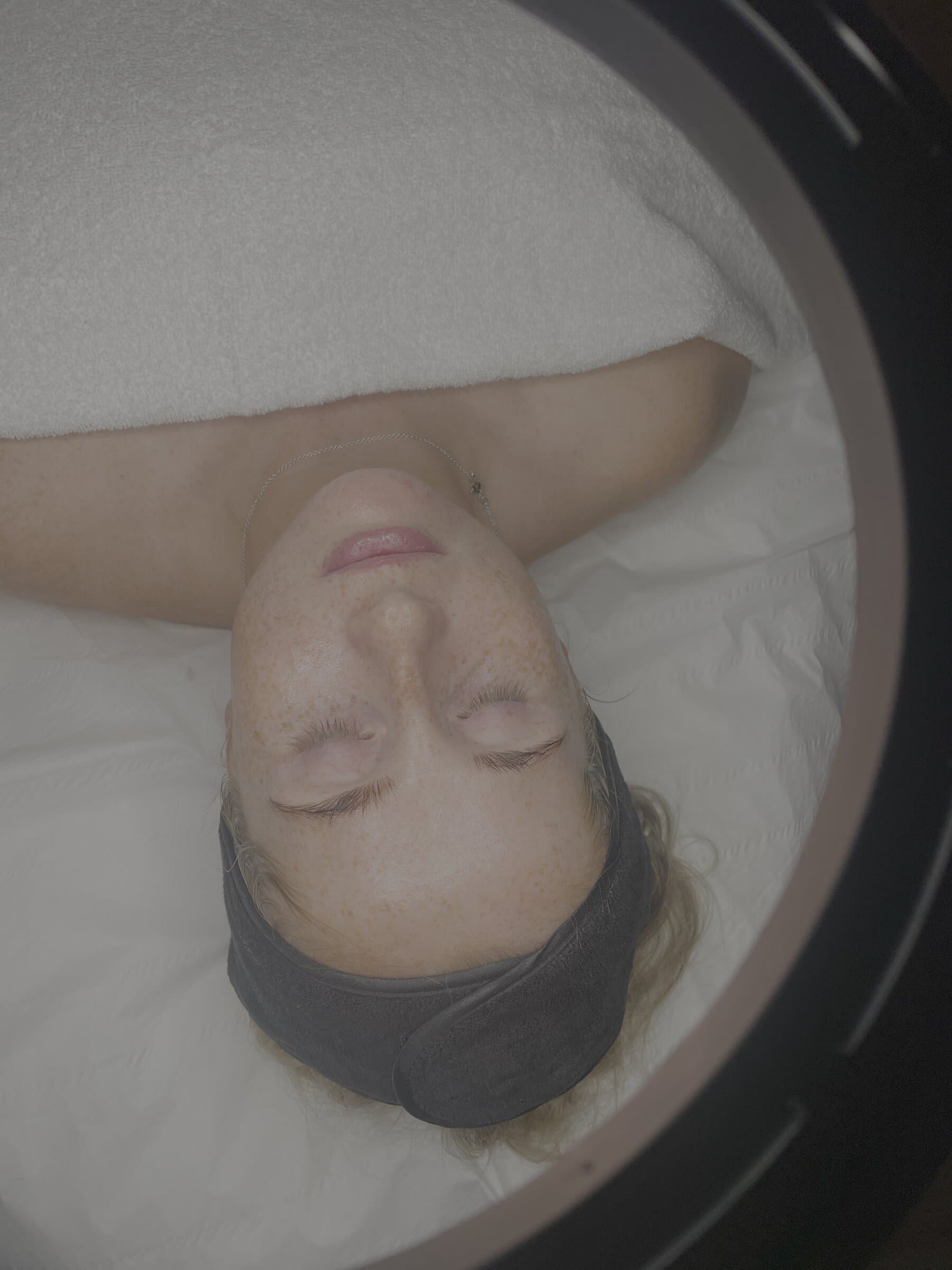 View through the Dermalux LED canopy as a client settles in for light therapy at Fresh Faced.
