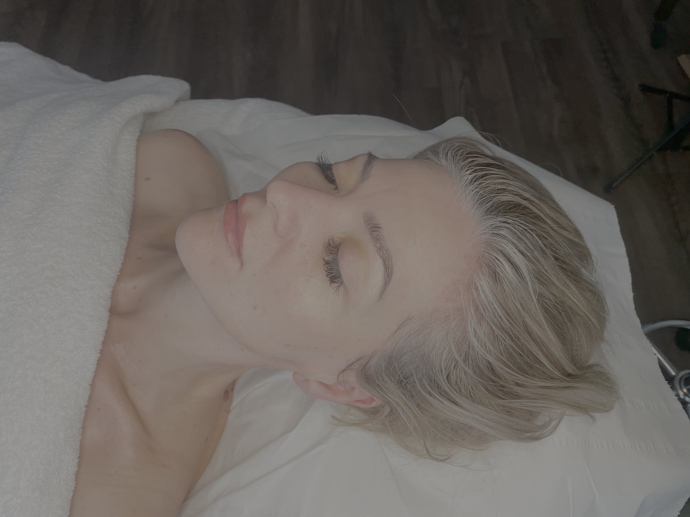Client at peace on the treatment bed after a facial at Fresh Faced Skin Clinic in Grimsby.