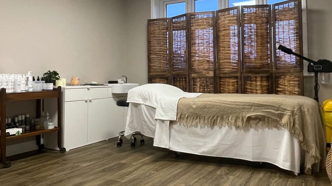 Calm treatment bed and trolley setup at Fresh Faced, dressed in soft neutrals.