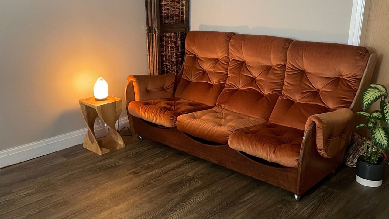 Warm welcome area at Fresh Faced with a burnt-orange sofa and natural light.