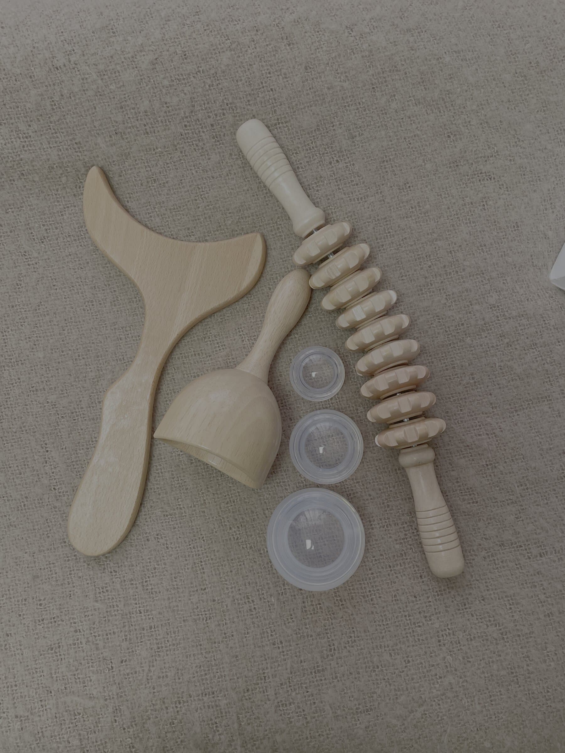 The Brazilian wood therapy kit at Fresh Faced, a flat-lay of shaped wooden sculpting tools and suction cups on natural linen.